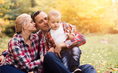 Fototapeta premium Little cute son playing with parents in forest