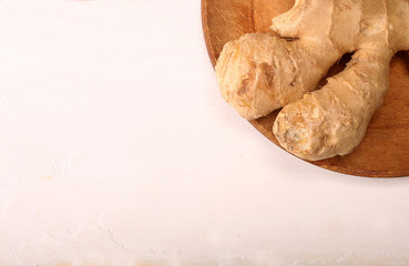 Healthy ginger root on cutting board and knife. Isolated on white background. Top view and copy space.