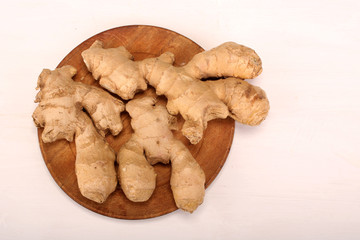 Healthy ginger root on cutting board and knife. Isolated on white background. Top view and copy space.