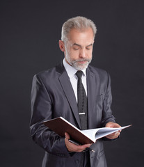 serious businessman signs a working document.isolated on black