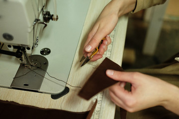 Closeup on woman sewing leather handbag