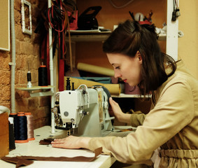 Closeup on woman sewing leather handbag