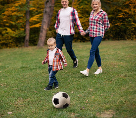 Son playing with ball on grass