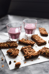 Healthy sugar free gluten free snack. Energetic granola bars with oats, almonds and amaranth seeds served with blueberry smoothie on dark background