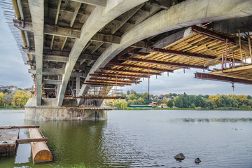 Concrete arches of the bridge for reconstruction on the background of water