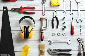 Flat lay composition with construction tools on wooden background