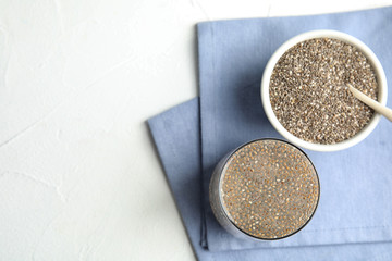 Flat lay composition with glass of water and chia seeds on white background, space for text