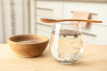 Composition with glass of water and chia seeds on table against blurred background