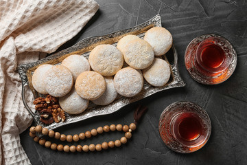 Flat lay composition with tray of traditional cookies for Islamic holidays on table. Eid Mubarak
