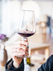 Male hand holding a glass of red wine  at wine tasting in Setugal wine region, Portugal