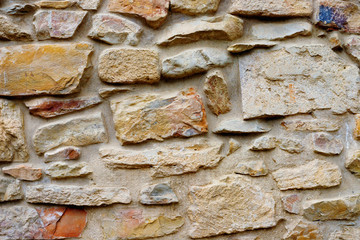 Texture collapsing stone wall of old house with brick masonry.