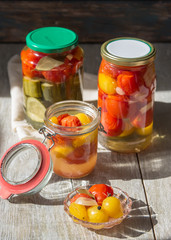 Fermented preserved vegetables in jar on wooden table. Copyspace