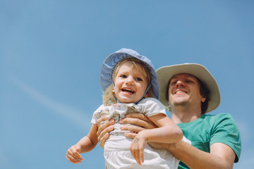 Father playing with happy little daughter outdoor on sunny day
