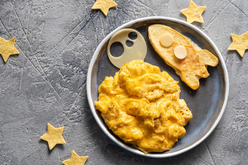 Kids funny breakfast with scrambled eggs, cheese and tortilla rocket