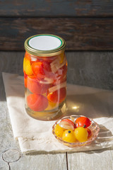 Fermented preserved vegetables in jar on wooden table. Copyspace