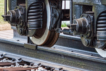 Old rusty railroad wagon weels with a chock brake.
