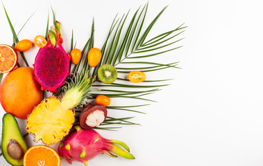 Still life with fresh assorted exotic fruits on a palm leaf.