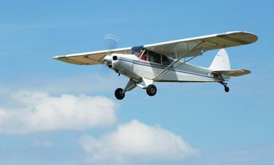 Fototapeta na wymiar Small sports airplane hovering highly in the sky outdoor
