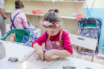 Little Girl At Pottery Workshop Shaping Clay Vase