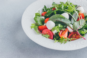 Healthy salad with cherry tomatoes, spinach and mozzarella