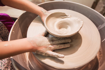 young potter hands working with clay on pottery wheel