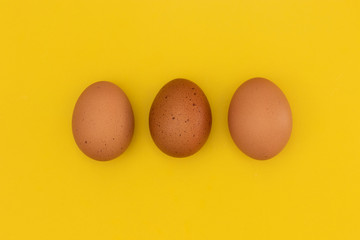 three easter eggs laying on a yellow background