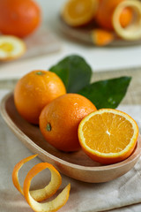 Oranges with leaves in a wooden bowl