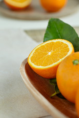 Oranges with leaves in a wooden bowl