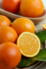 Oranges with leaves in a wooden bowl