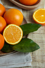 Oranges with leaves in a wooden bowl