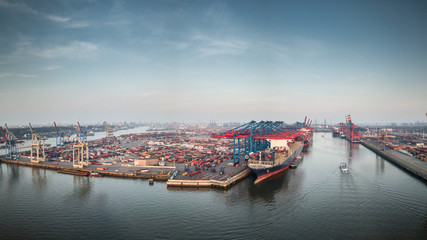 Fototapeta premium Waltershofer Hafen im Hamburger Hafen mit Köhlbrandbrücke und Skyline von Hamburg