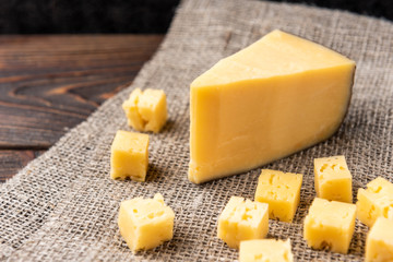 Parmesan cheese on dark wooden background.