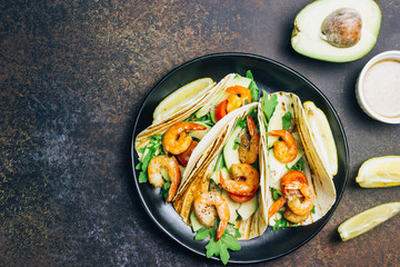 Tortilla tacos with arugula, lemon, avocado and grilled shrimp pawns.