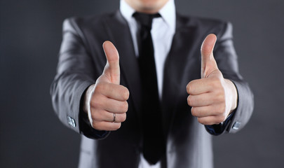 close up.modern businessman showing thumbs up. isolated on black