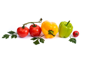 Cherry tomatoes with greens and sweet peppers on a white background. Green pepper and yellow with tomatoes and herbs on a white background.