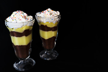 Two pudding parfaits on a black background