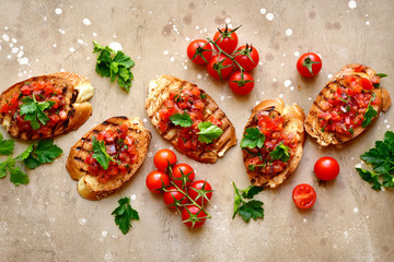 Toasts with cherry tomatoes, red onion and olive oil.Top view with copy space.