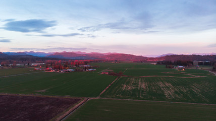 Mountains, river in the background. Aerial of farm field