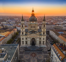 Fototapeta premium Budapest, Hungary - Aerial view of famous St. Stephen's Basilica in the morning with golden amd blue sky and rising sun at right behind the building