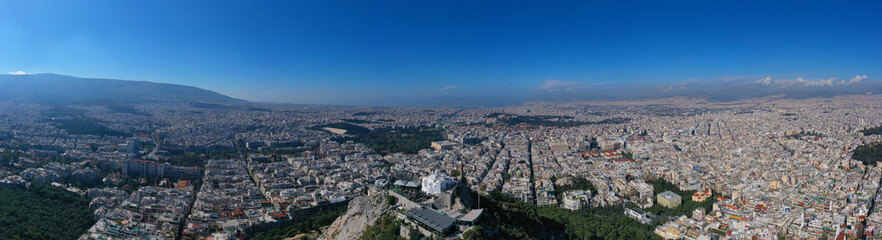 Fototapeta premium Aerial drone panoramic photo of iconic Saint George Lycabettus chapel as seen from top of hill, all Athens cityscape and Acropolis hill at the background, Athens historic centre, Attica, Greece