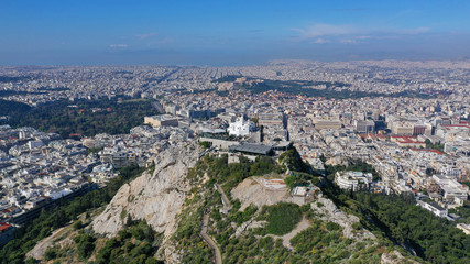 Fototapeta na wymiar Aerial drone panoramic photo of iconic Saint George Lycabettus chapel as seen from top of hill, all Athens cityscape and Acropolis hill at the background, Athens historic centre, Attica, Greece