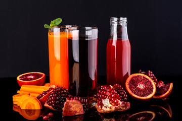 Different healthy vegan drinks on the black background. Raw drinks and foods.
