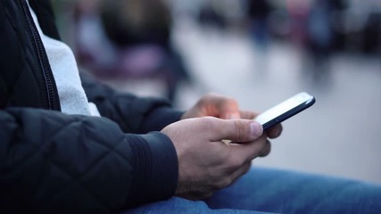 Close-up View of Man Using Smartphone in the city street
