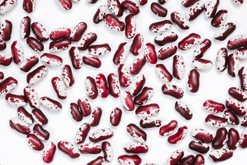 Pile of ripe speckled kidney Anasazi beans, with vivid burgundy color isolated on white background. Close-up.