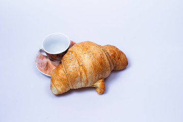 croissant with little cup on a plate isolated on white