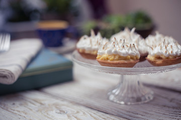 Fototapeta na wymiar Lemon meringue pie on white wooden board with romantic decor 