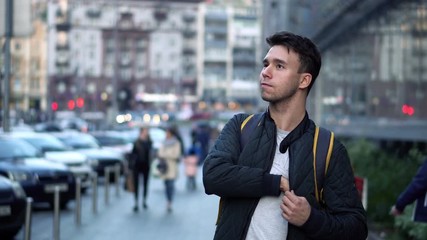 Young Attractive Man Walking on Street and Using Smartphone