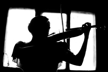 silhouette of a woman playing violin