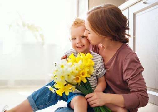 happy mother's day! child son gives flowersfor  mother on holiday .