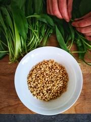 Woman's hands holding wild garlic leaves to prepare wild garlic pesto, pine nuts